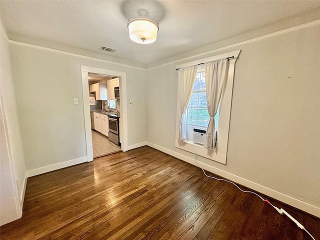 unfurnished room featuring crown molding, sink, cooling unit, and hardwood / wood-style flooring