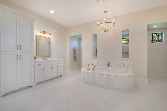 bathroom featuring vanity, tile patterned floors, a bathtub, and a notable chandelier