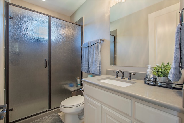 bathroom featuring vanity, an enclosed shower, and toilet