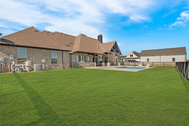 back of house featuring a patio, a yard, and central AC