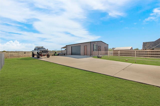 view of yard with a garage and an outbuilding