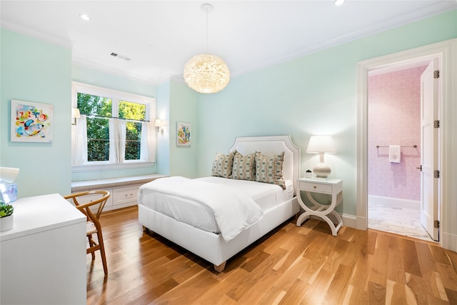 bedroom featuring connected bathroom, light hardwood / wood-style flooring, and ornamental molding