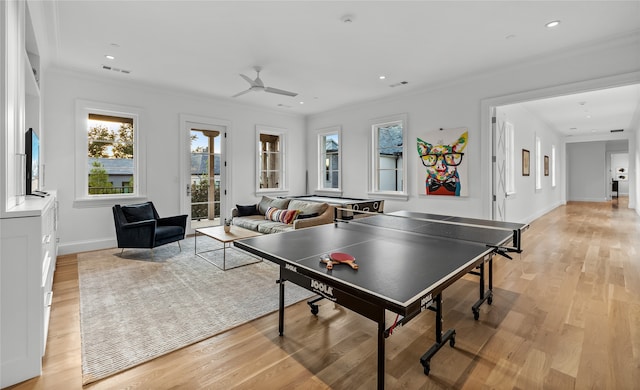 recreation room with ceiling fan, light hardwood / wood-style floors, and ornamental molding