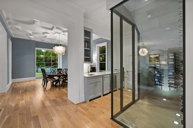 interior space with gray cabinets, light hardwood / wood-style floors, a healthy amount of sunlight, and wine cooler