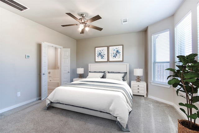 carpeted bedroom with ceiling fan and ensuite bath