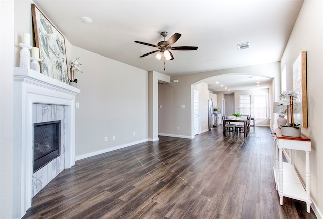 unfurnished living room with a fireplace, dark hardwood / wood-style flooring, and ceiling fan