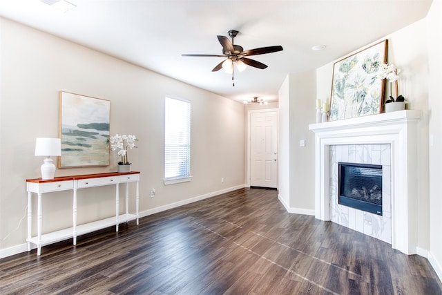 unfurnished living room featuring dark hardwood / wood-style floors, ceiling fan, and a tiled fireplace