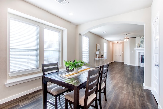 dining area with ceiling fan and dark wood-type flooring