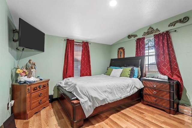 bedroom featuring lofted ceiling and light hardwood / wood-style flooring