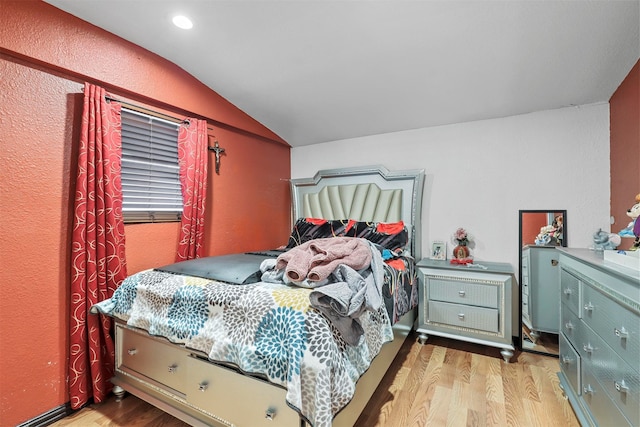 bedroom featuring lofted ceiling and light wood-type flooring