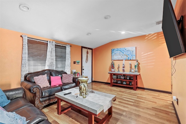 living room featuring light wood-type flooring and vaulted ceiling