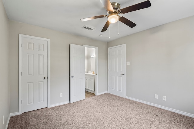 unfurnished bedroom with ceiling fan, ensuite bathroom, and light colored carpet