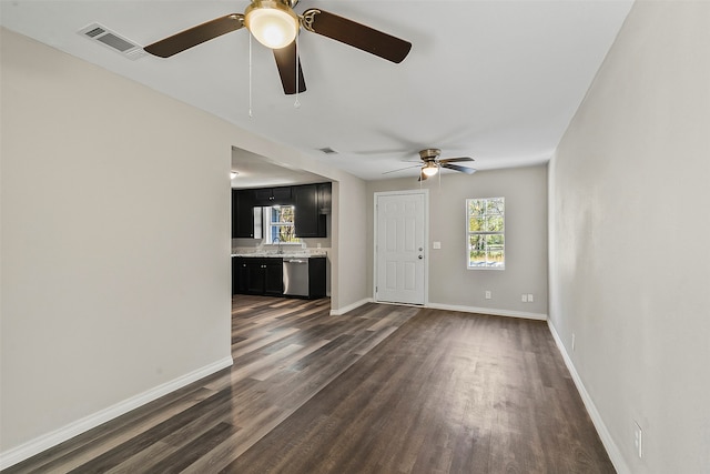 unfurnished living room featuring ceiling fan, sink, and dark wood-type flooring