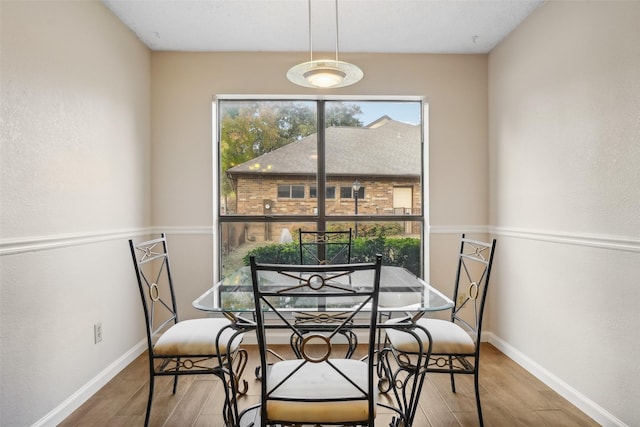 dining space with wood finished floors and baseboards