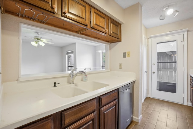 kitchen with light wood finished floors, ceiling fan, light countertops, stainless steel dishwasher, and a sink