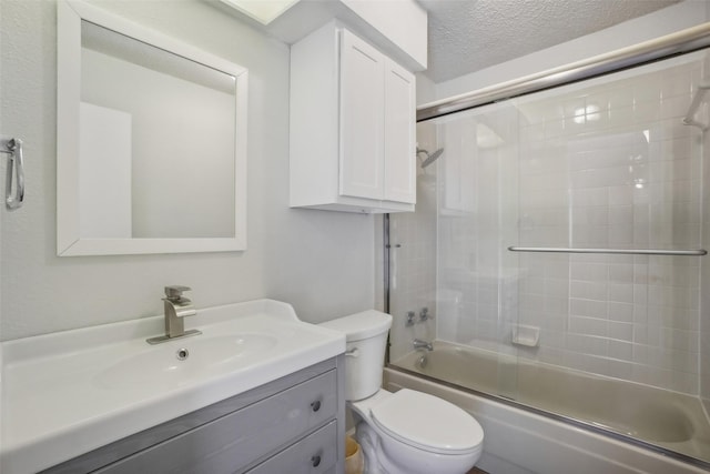 bathroom featuring enclosed tub / shower combo, a textured ceiling, vanity, and toilet