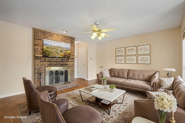 living room with ceiling fan, dark hardwood / wood-style floors, and a brick fireplace