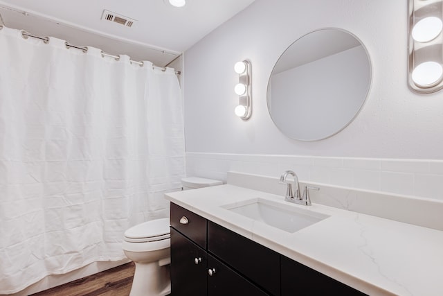 bathroom featuring toilet, vanity, and hardwood / wood-style flooring