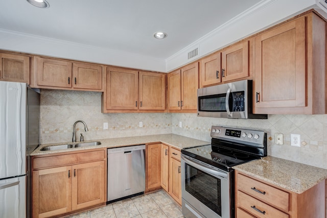 kitchen featuring appliances with stainless steel finishes, light stone counters, ornamental molding, sink, and light tile patterned floors