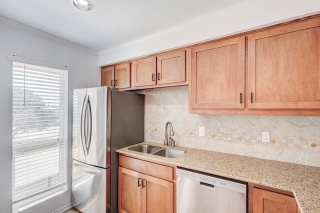 kitchen featuring stainless steel appliances, light stone counters, crown molding, and sink