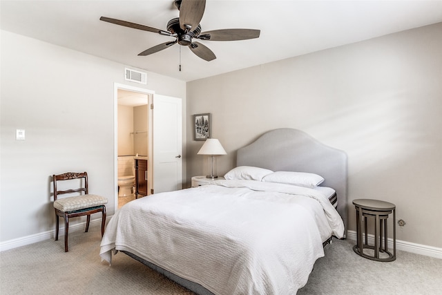 bedroom with ensuite bathroom, carpet, and ceiling fan