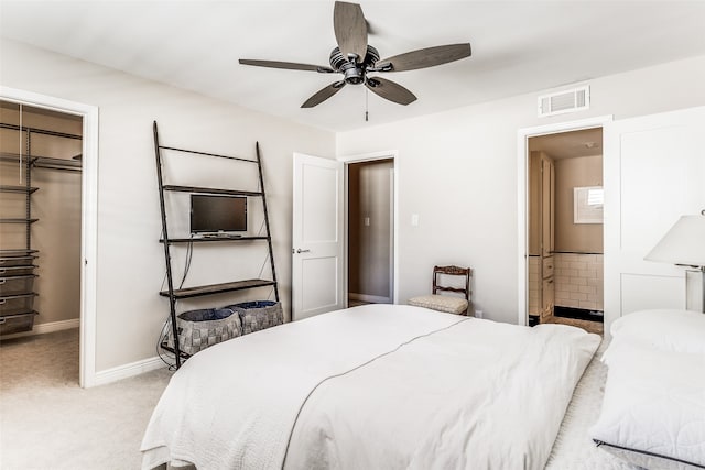 bedroom with ensuite bath, ceiling fan, light carpet, a walk in closet, and a closet