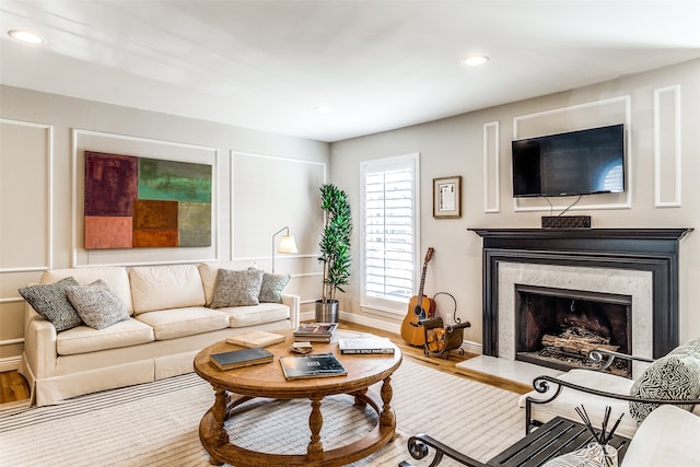 living room with hardwood / wood-style floors and a high end fireplace