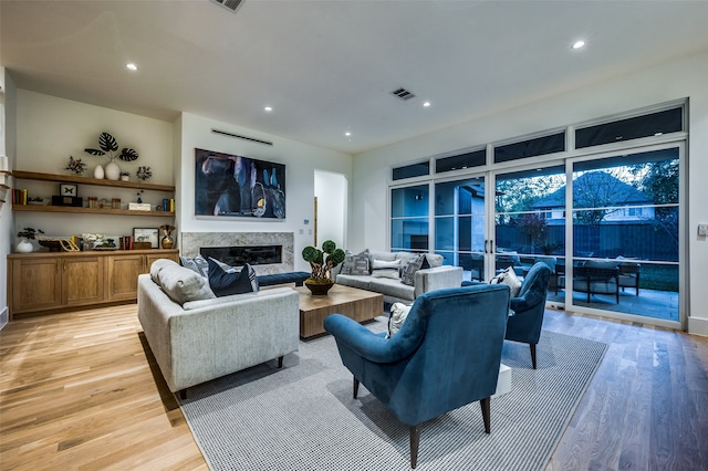 living room featuring a premium fireplace and light hardwood / wood-style floors