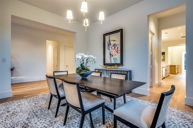 dining area featuring a notable chandelier and light wood-type flooring