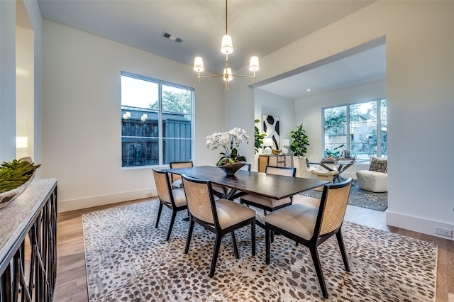 dining room featuring a notable chandelier, plenty of natural light, and light hardwood / wood-style floors