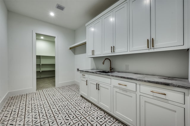 kitchen featuring white cabinetry and sink