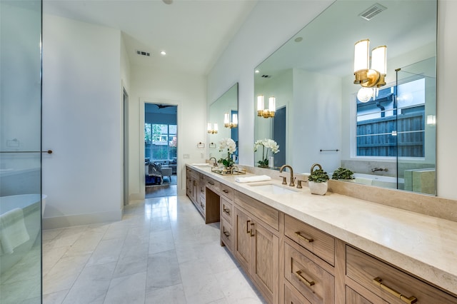 bathroom with tile patterned floors, a tub, vanity, and a notable chandelier