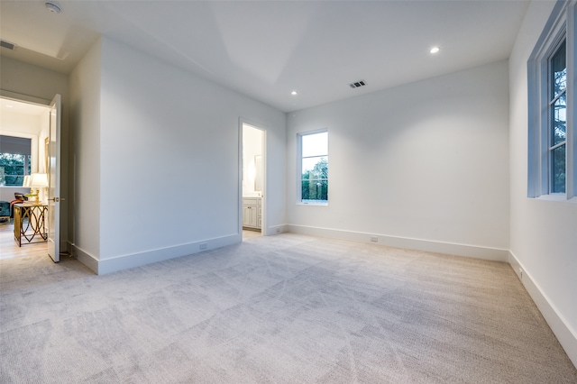 unfurnished room featuring light carpet