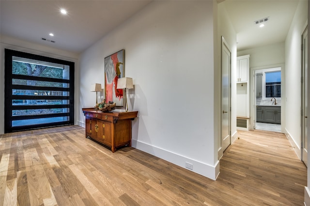 hallway featuring light hardwood / wood-style floors and sink