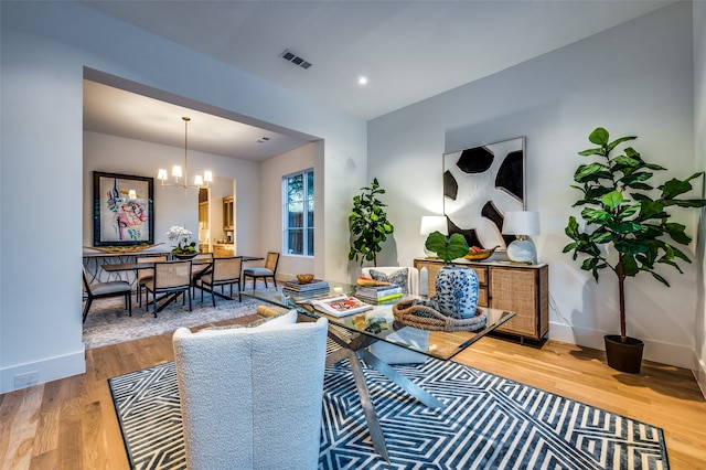 living room with hardwood / wood-style floors and a notable chandelier