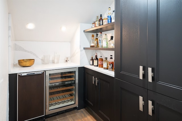 bar with fridge, hardwood / wood-style floors, beverage cooler, and lofted ceiling