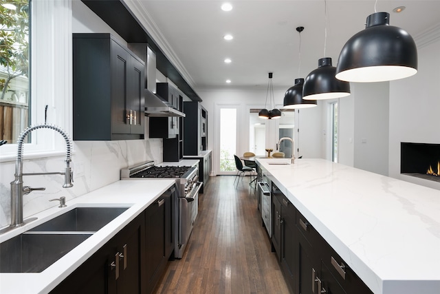 kitchen featuring sink, hanging light fixtures, dark hardwood / wood-style flooring, high end stove, and backsplash