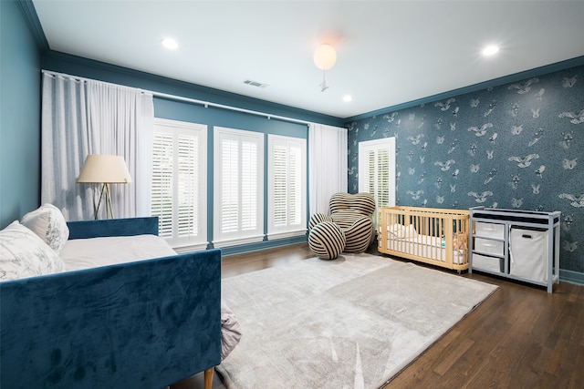 bedroom with crown molding and dark wood-type flooring