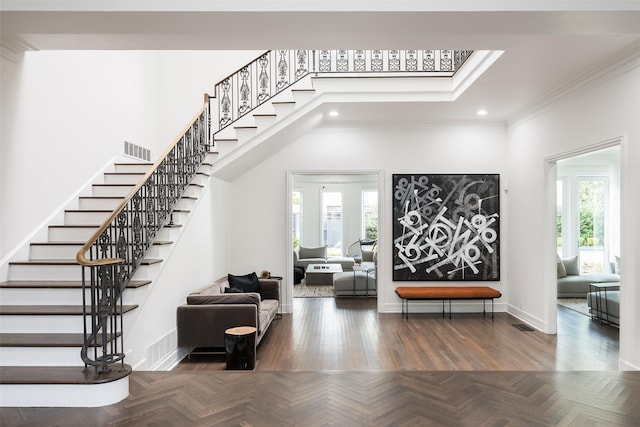 stairs featuring parquet flooring, ornamental molding, and a high ceiling