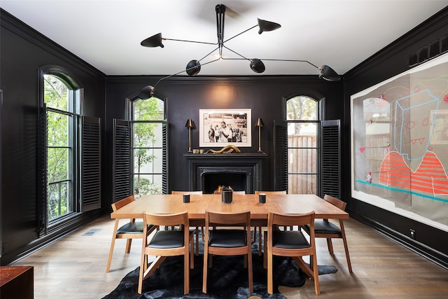 dining area with a wealth of natural light, hardwood / wood-style flooring, and ornamental molding