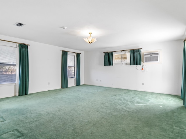 carpeted spare room featuring a wall unit AC