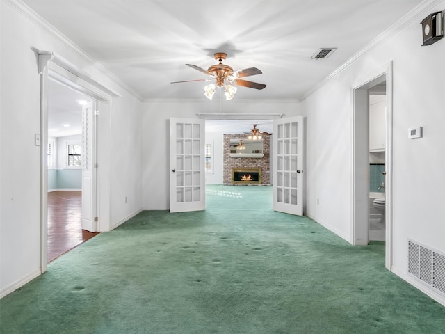 spare room featuring french doors, crown molding, and carpet floors