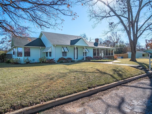 ranch-style house with a sunroom and a front lawn