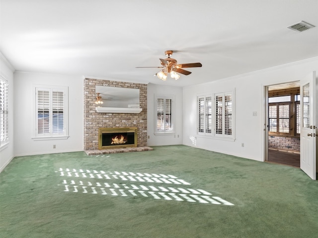 unfurnished living room featuring a fireplace, carpet floors, and ornamental molding