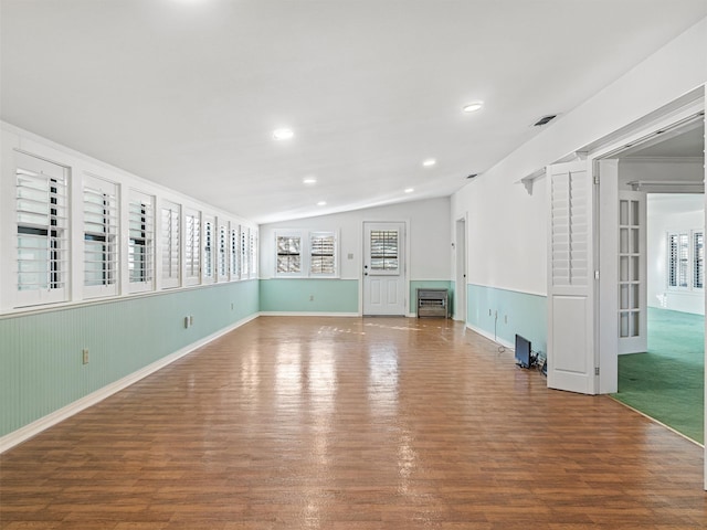 spare room with vaulted ceiling and hardwood / wood-style floors