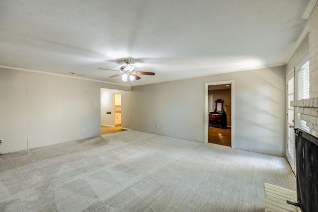 unfurnished living room with crown molding, a fireplace, and light colored carpet