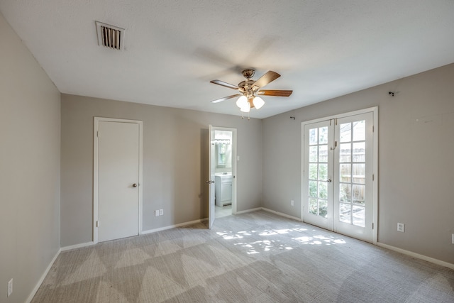 carpeted spare room with ceiling fan, french doors, and washer / dryer