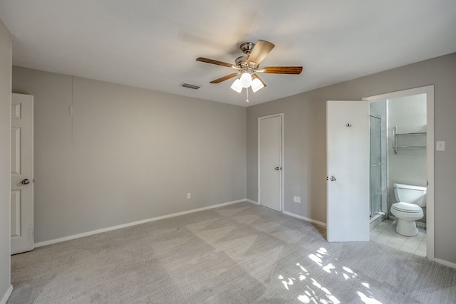 unfurnished bedroom featuring ceiling fan, a closet, light carpet, and ensuite bath