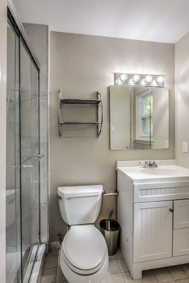 bathroom featuring tile patterned floors, vanity, toilet, and an enclosed shower