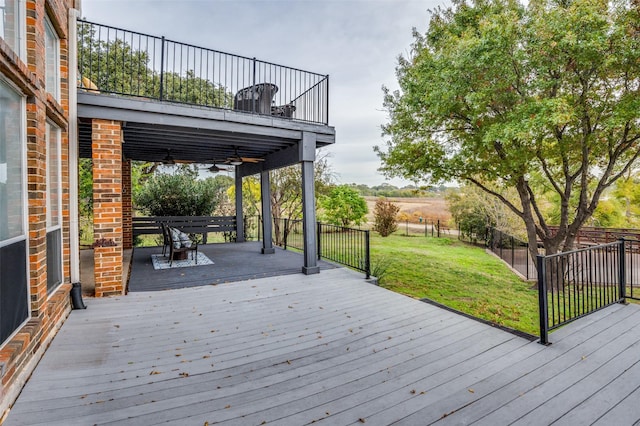 deck featuring ceiling fan and a yard